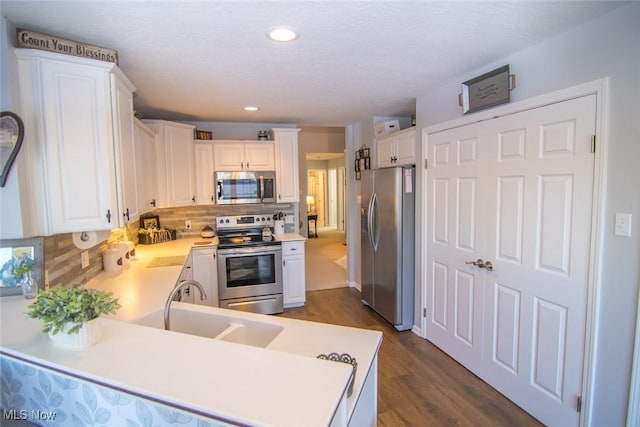 kitchen featuring stainless steel appliances, decorative backsplash, and white cabinetry