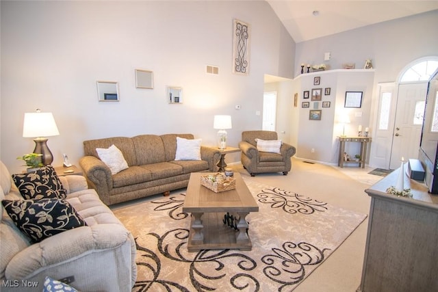 living room featuring high vaulted ceiling and carpet