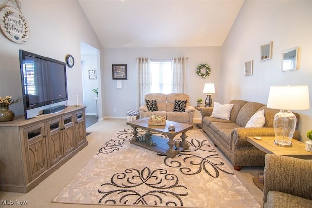 living room featuring lofted ceiling and light carpet