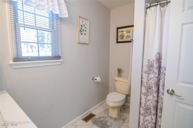 bathroom with curtained shower and toilet