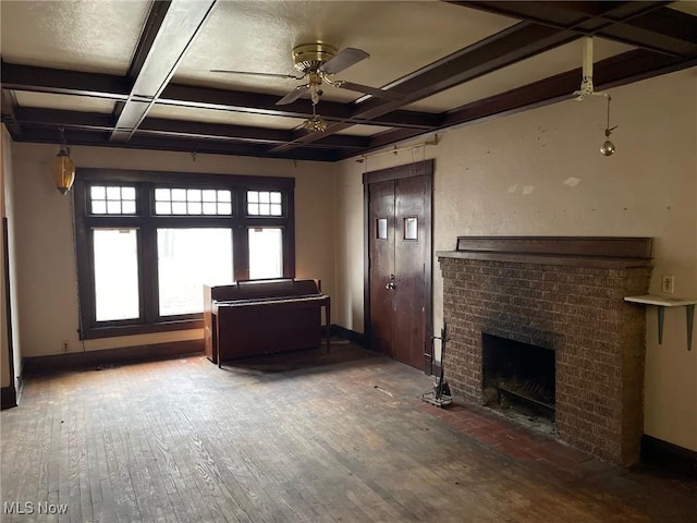 unfurnished living room featuring beamed ceiling, coffered ceiling, hardwood / wood-style floors, and a brick fireplace