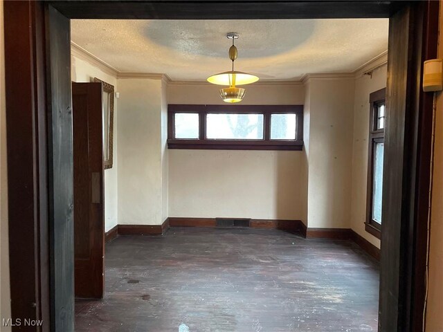 unfurnished room with crown molding and a textured ceiling