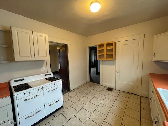 kitchen featuring light tile patterned flooring and white cabinets