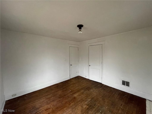 empty room with dark wood-type flooring