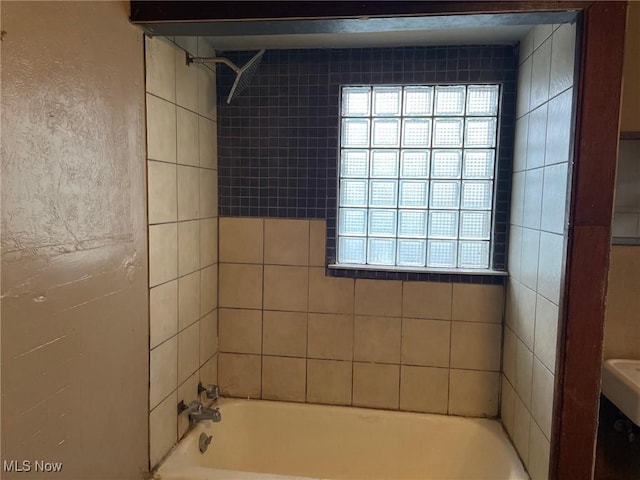 bathroom with tiled shower / bath combo and plenty of natural light