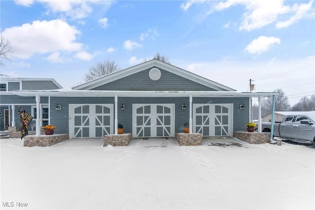 snow covered property with a garage