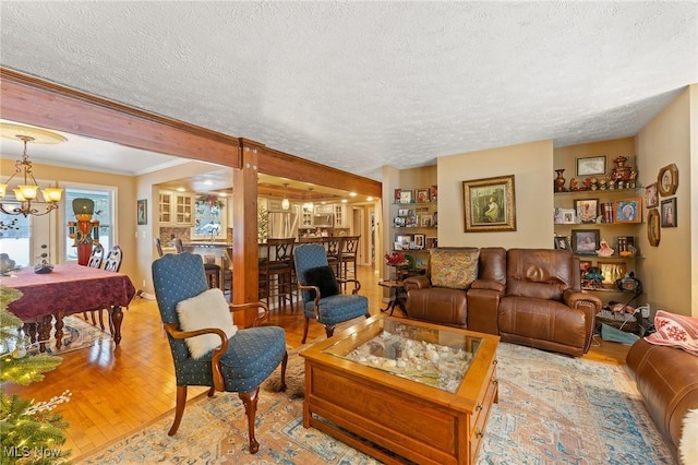 living area with a chandelier, a textured ceiling, wood finished floors, and crown molding