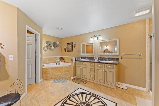 bathroom with double vanity, a sink, baseboards, and a bath