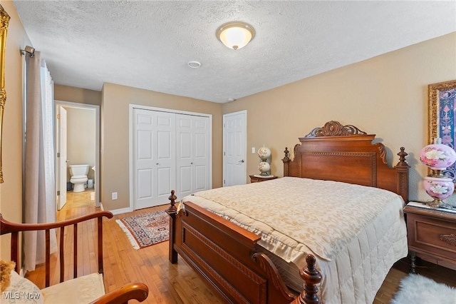 bedroom featuring a closet, a textured ceiling, and hardwood / wood-style floors