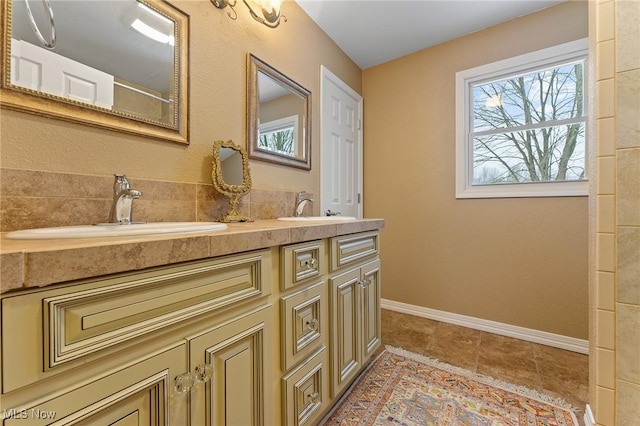 bathroom featuring double vanity, tile patterned floors, a sink, and baseboards