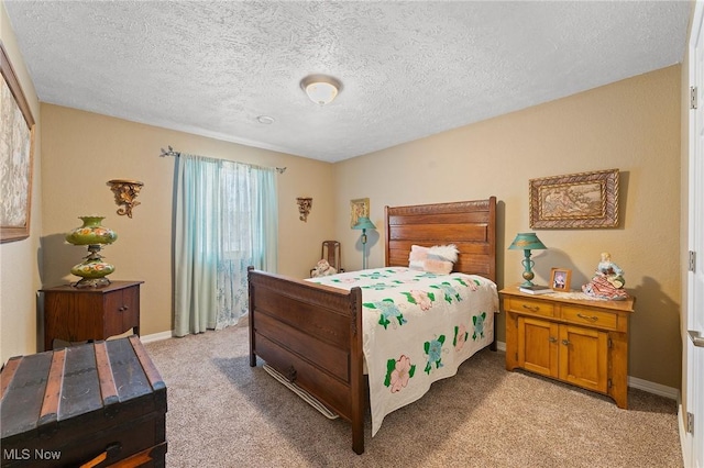 bedroom featuring baseboards, a textured ceiling, and light colored carpet