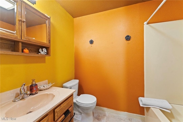 bathroom with toilet, baseboards, and vanity