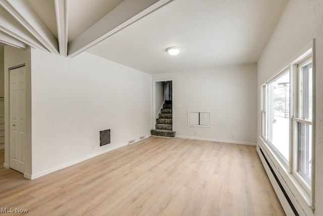 empty room with light hardwood / wood-style flooring, a baseboard radiator, and beamed ceiling