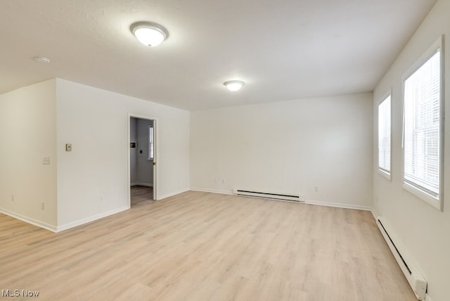 empty room with baseboard heating and light wood-type flooring