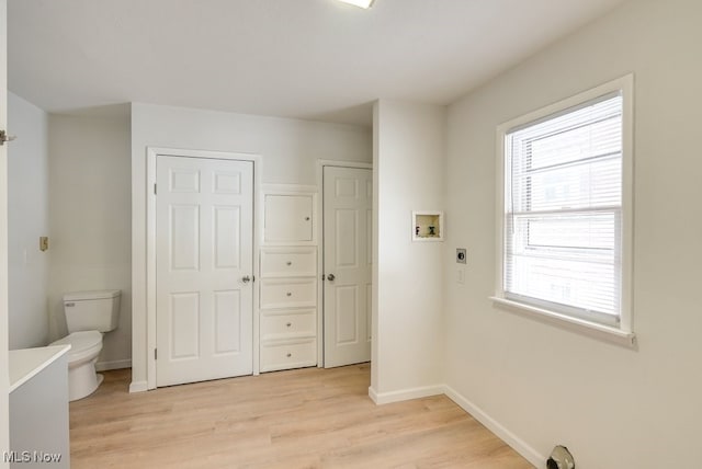 washroom featuring electric dryer hookup, a wealth of natural light, light hardwood / wood-style floors, and washer hookup