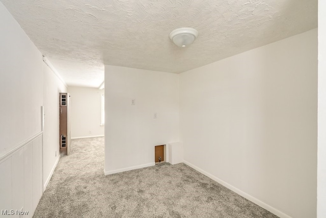 carpeted spare room featuring a textured ceiling