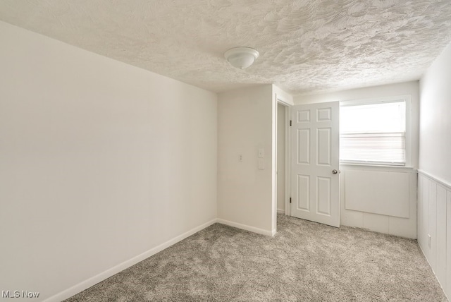 carpeted empty room with a textured ceiling