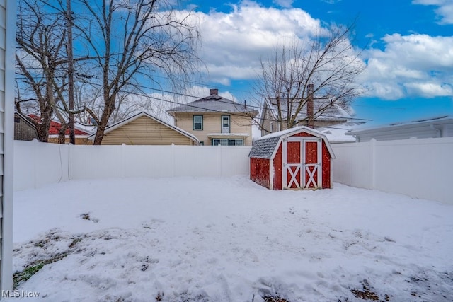 yard covered in snow with a shed