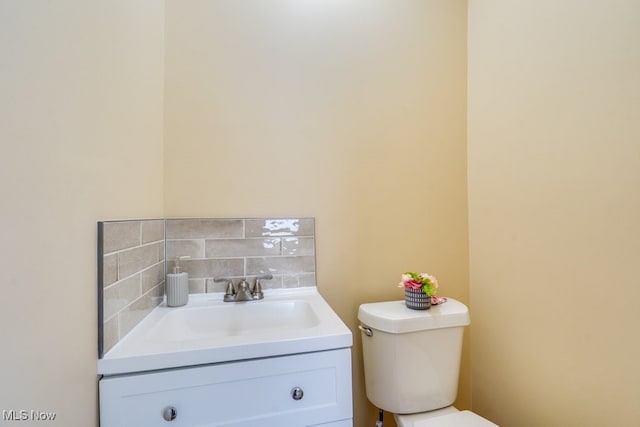 bathroom featuring tasteful backsplash, vanity, and toilet