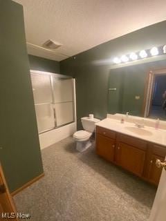 full bathroom featuring a textured ceiling, bath / shower combo with glass door, vanity, and toilet