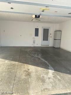 garage with white refrigerator and a garage door opener