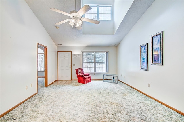 unfurnished room featuring ceiling fan, high vaulted ceiling, light carpet, and a textured ceiling