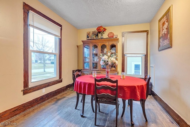 dining space featuring a textured ceiling and dark hardwood / wood-style flooring