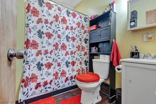 bathroom featuring toilet, a textured ceiling, wood-type flooring, a shower with shower curtain, and vanity