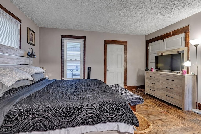 bedroom featuring a textured ceiling and light hardwood / wood-style flooring