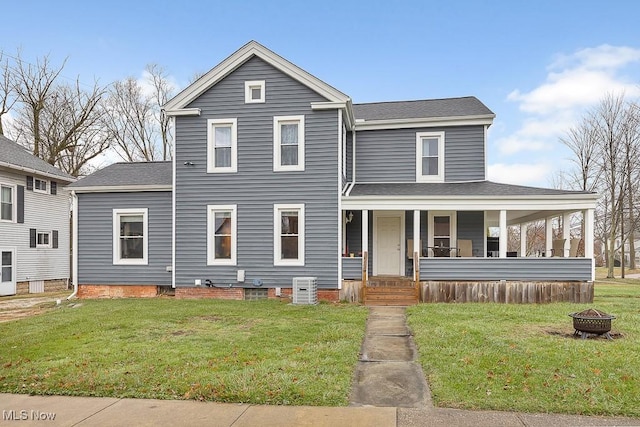 view of front of property featuring covered porch, an outdoor fire pit, and a front lawn