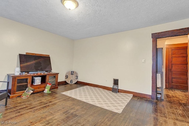 interior space with dark wood-type flooring and a textured ceiling