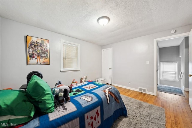 bedroom with a textured ceiling and hardwood / wood-style floors