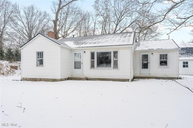 view of snow covered rear of property