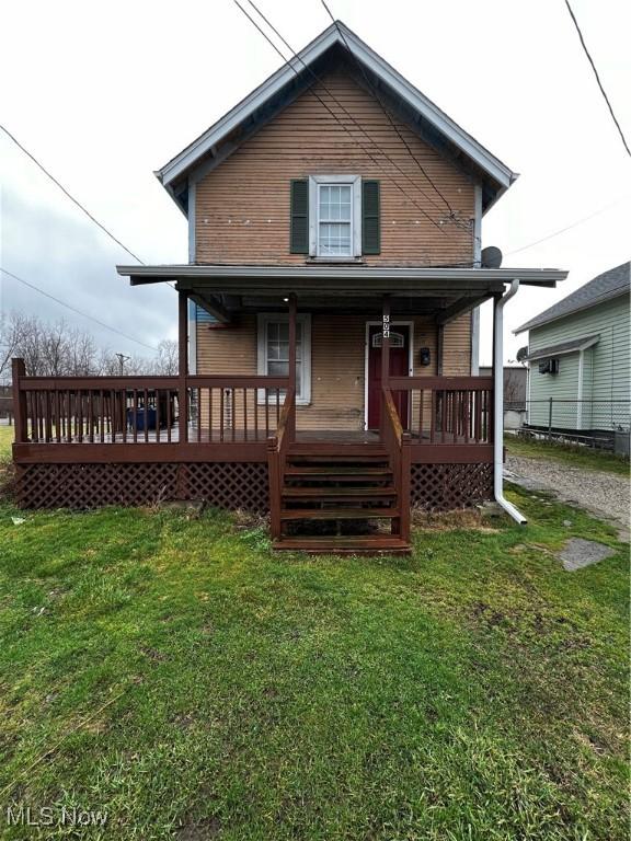 rear view of property featuring a yard