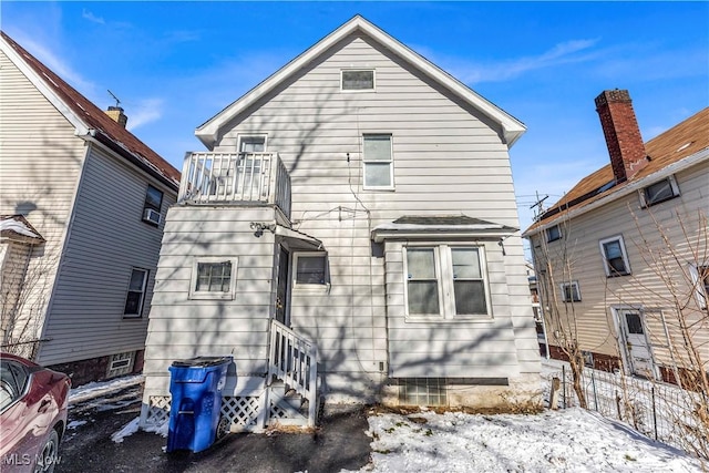 snow covered property with a balcony