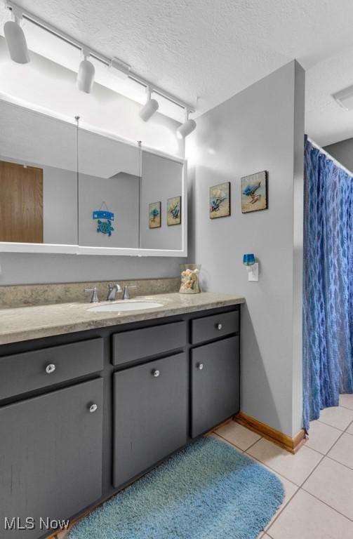 bathroom featuring tile patterned flooring, vanity, and a textured ceiling