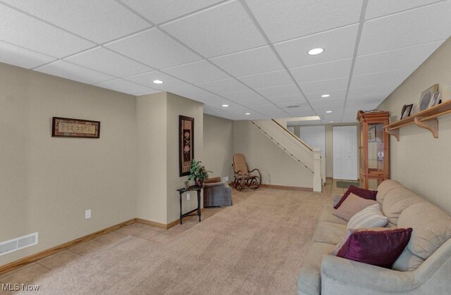 carpeted living room featuring a drop ceiling