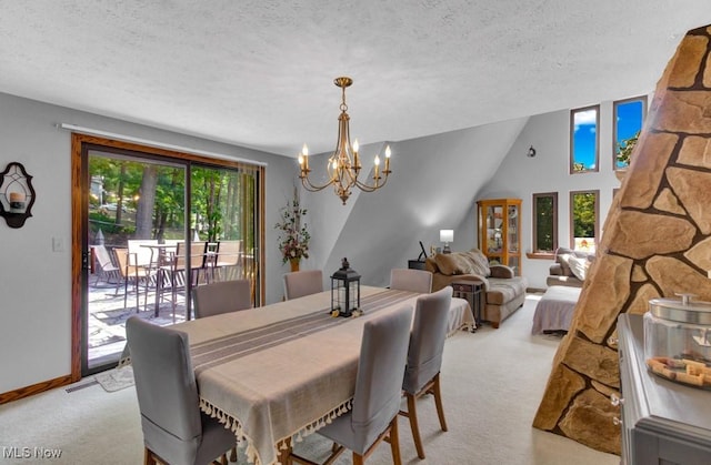 dining area featuring a textured ceiling, a chandelier, and light carpet