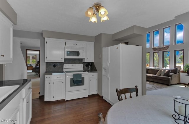 kitchen featuring white appliances, dark wood-type flooring, white cabinets, and backsplash