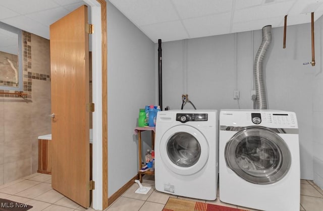 clothes washing area featuring washing machine and dryer and light tile patterned floors