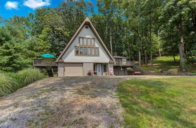 view of front of house featuring a garage, a wooden deck, and a front lawn