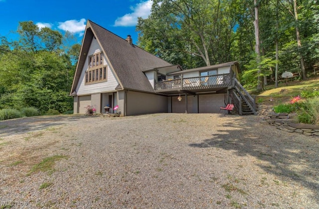 view of front facade with a garage and a wooden deck