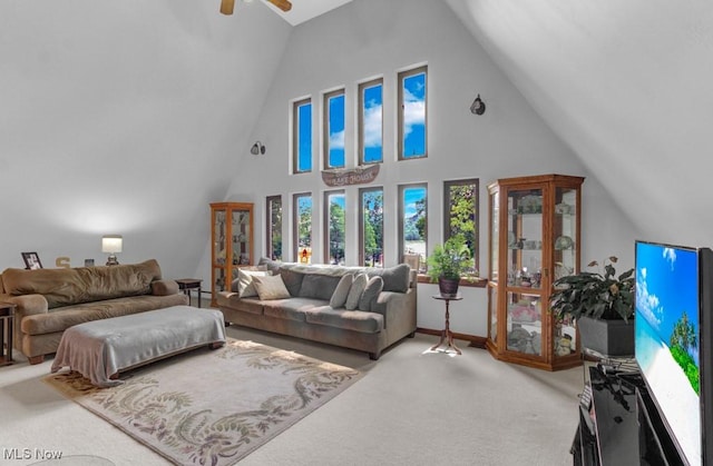 carpeted living room featuring a towering ceiling and ceiling fan