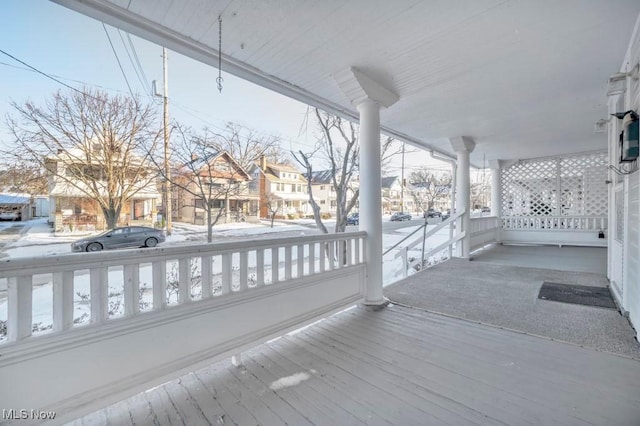 snow covered deck featuring covered porch