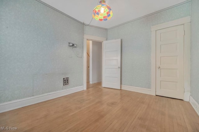 unfurnished bedroom with light hardwood / wood-style floors and crown molding