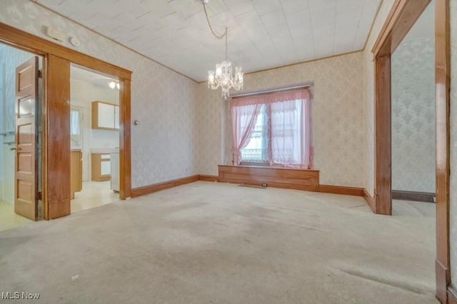 spare room featuring a chandelier and carpet flooring