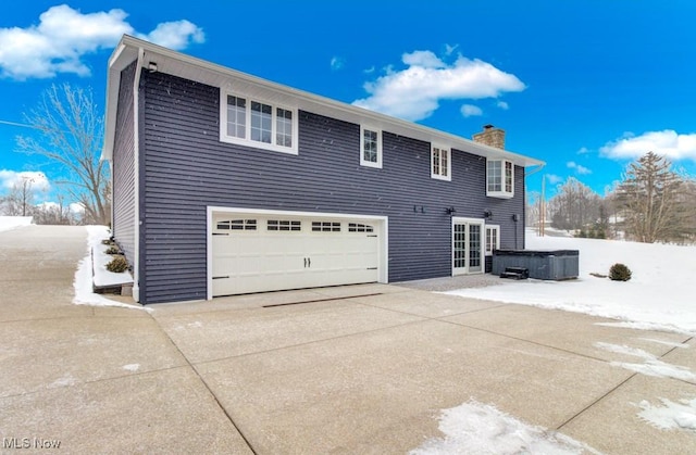 view of snow covered exterior featuring a garage