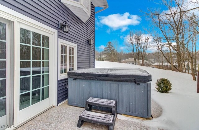 snow covered patio with a hot tub