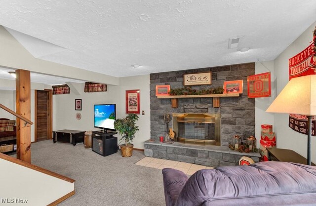 living room featuring a fireplace, light colored carpet, and a textured ceiling