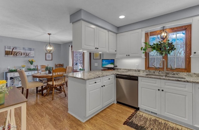 kitchen featuring white cabinetry, pendant lighting, sink, and stainless steel dishwasher